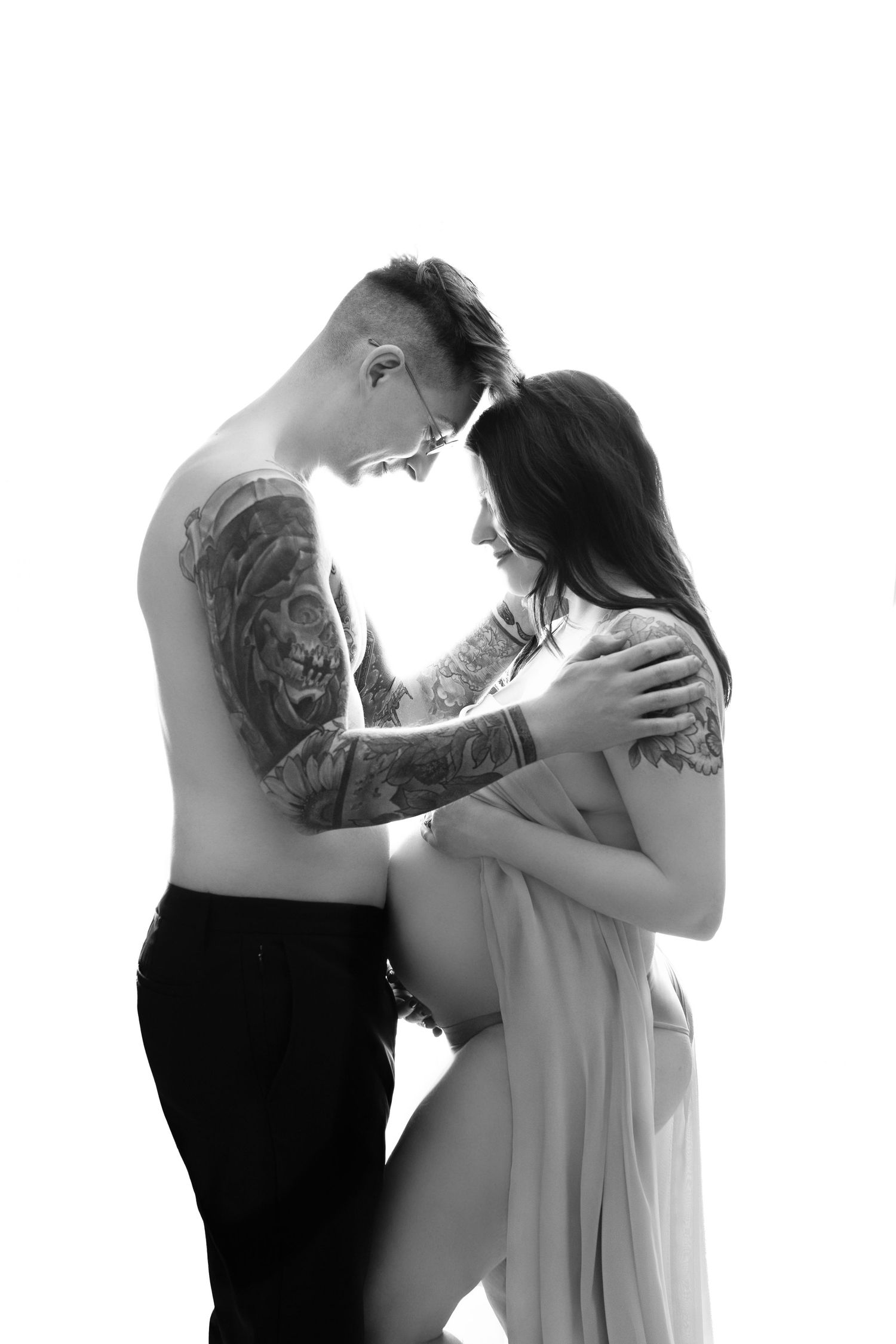 High contrast black and white maternity couple photos with dramatic lighting.