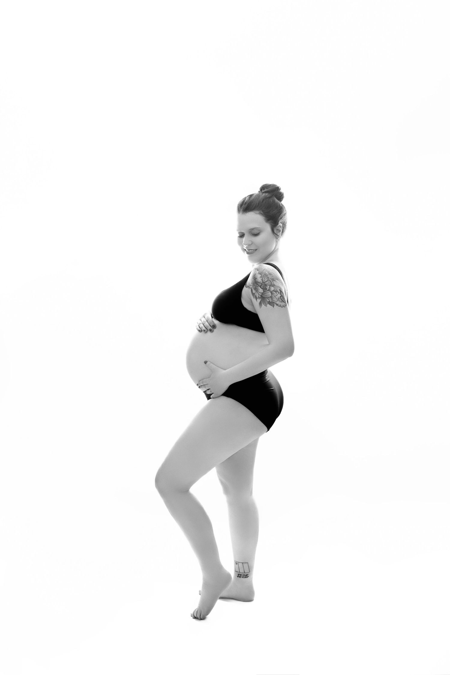 Minimalist black and white maternity poses against white background.