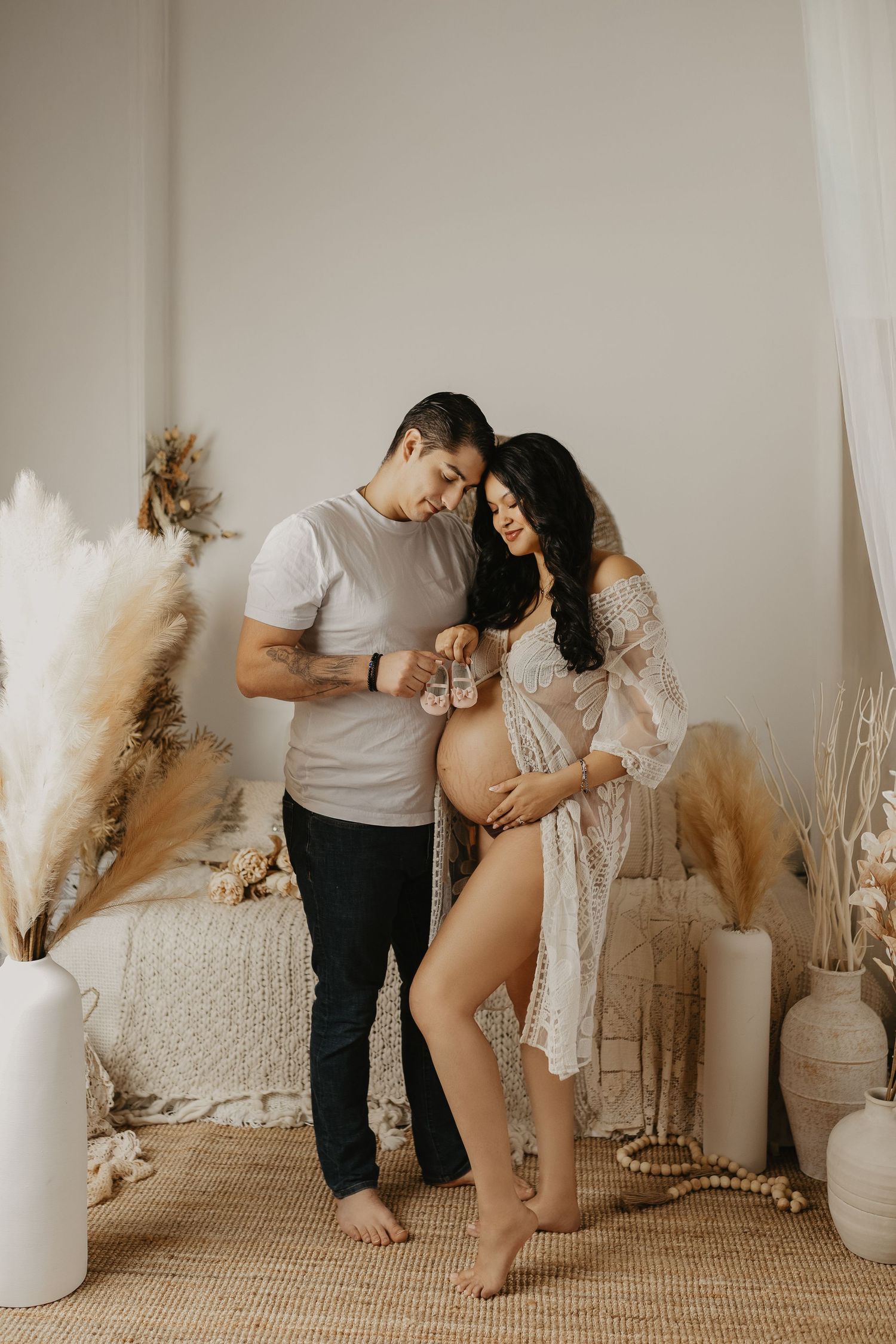 Intimate maternity couple photos with neutral decor and pampas grass accents.