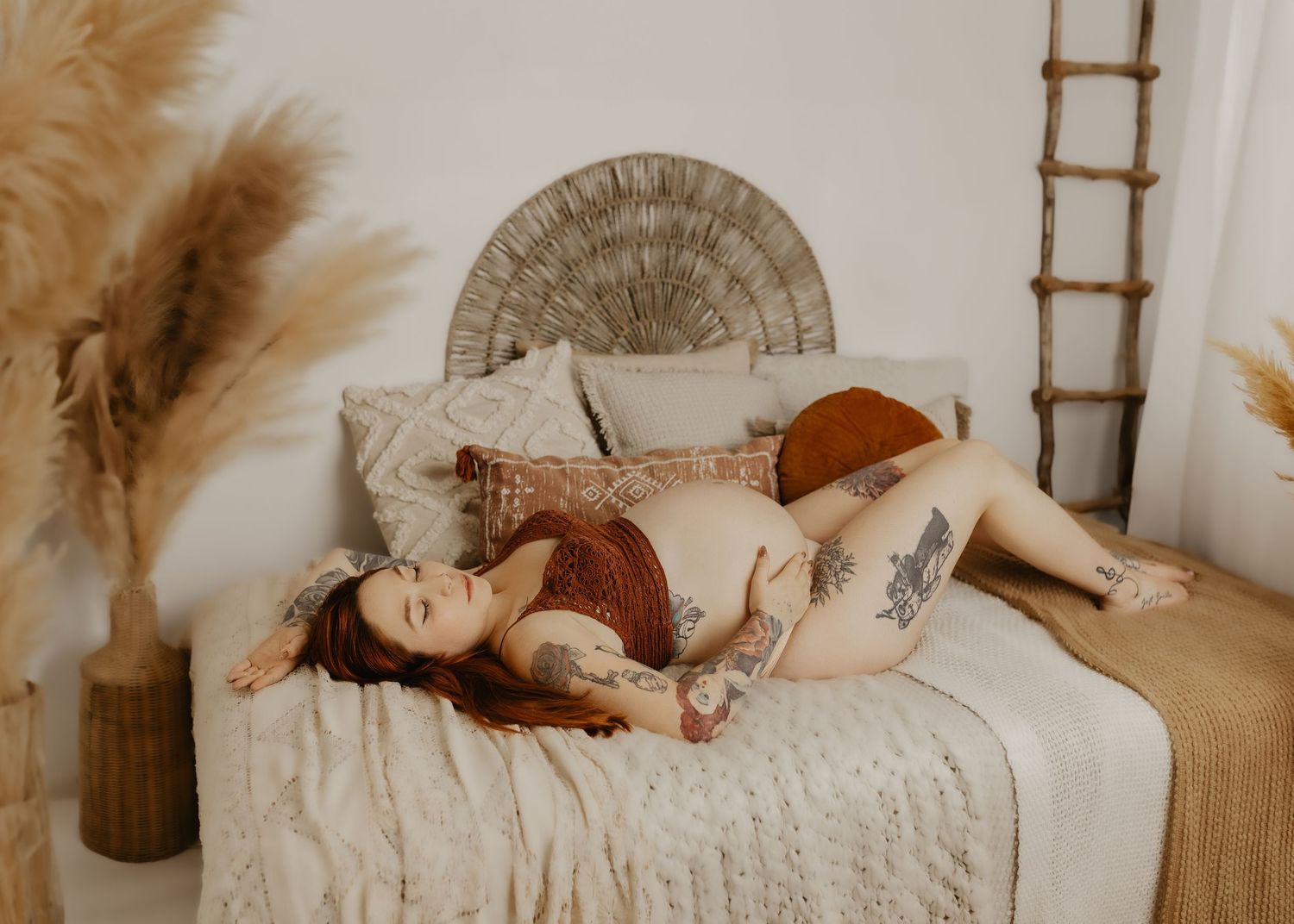 Neutral-toned newborn photography setup with wooden ladder and soft textiles.