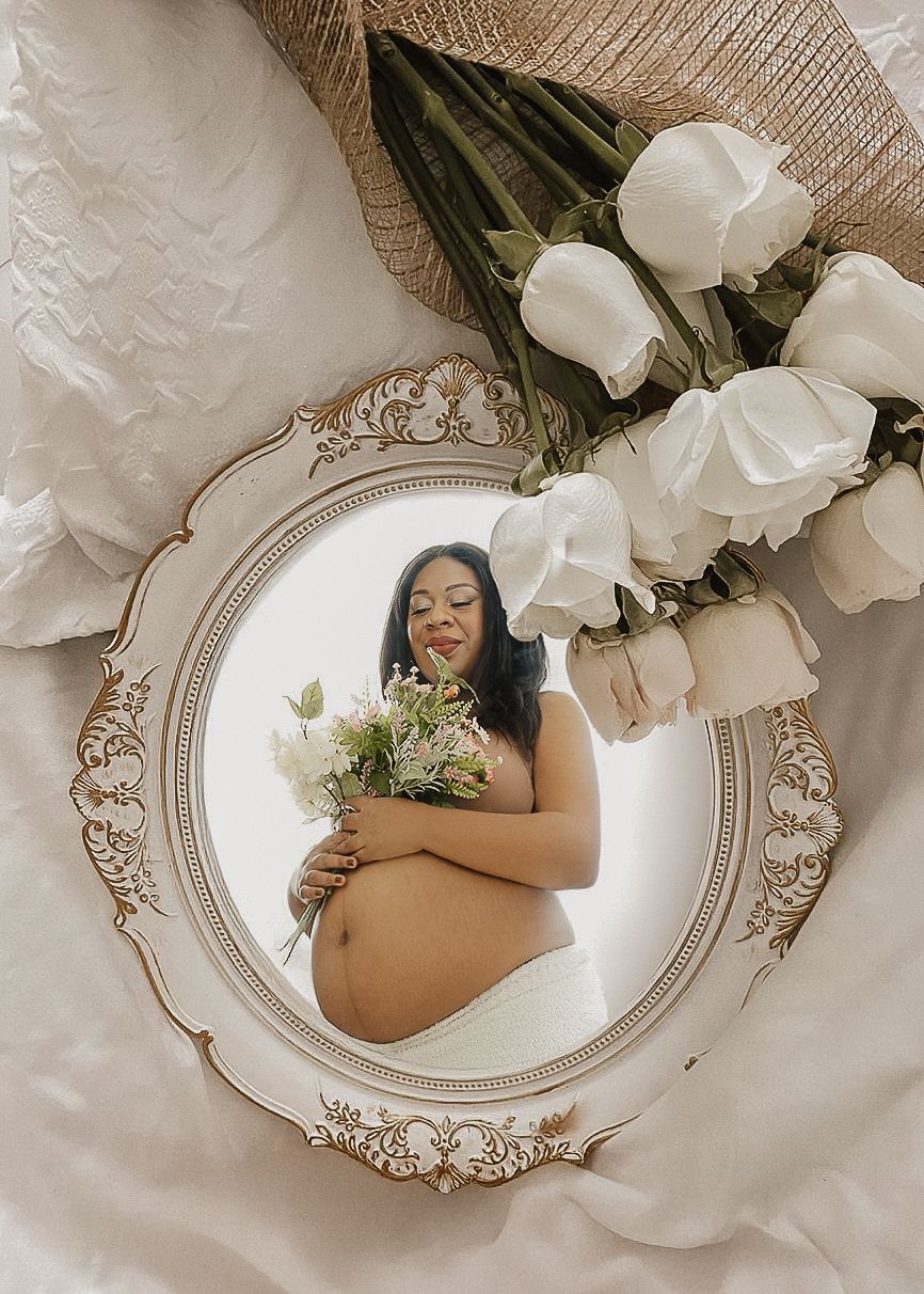 Elegant maternity photos arranged in vintage-style mirrors with white floral decorations.