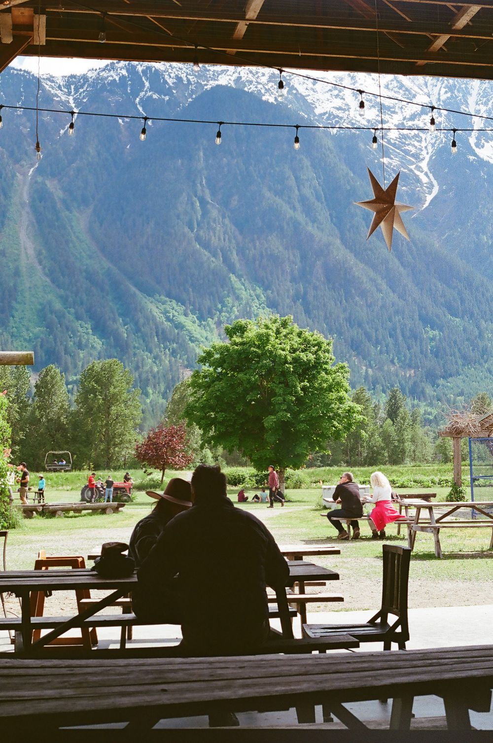 Outdoor seating area with mountain view and hanging string lights creating a cozy atmosphere.