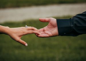 Hands gracefully touch during engagement portrait session.