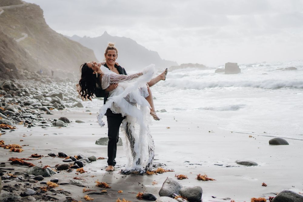 A romantic beach photoshoot with dramatic coastal cliffs and crashing waves.