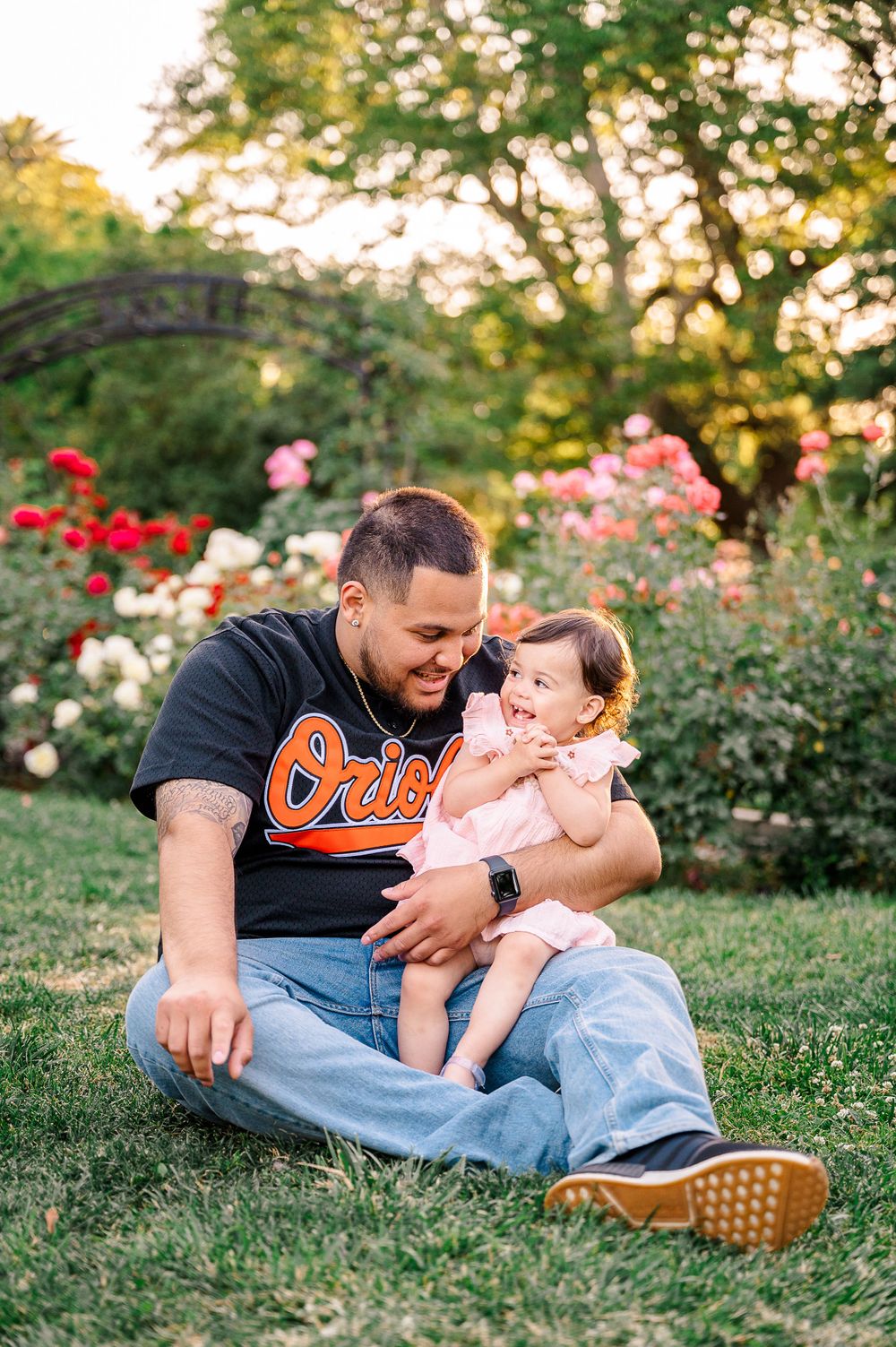 Father and toddler girl sitting in McKinley rose garden