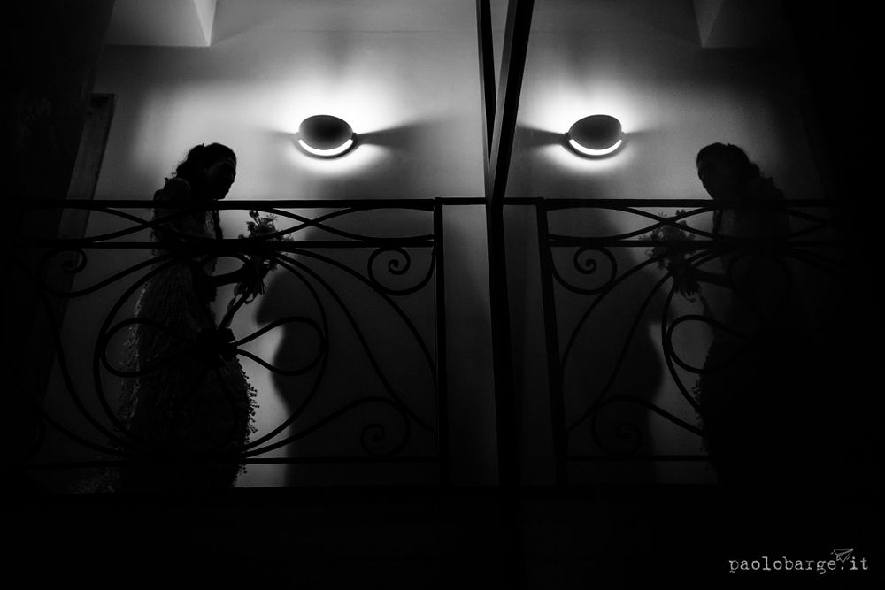Dramatic silhouettes against wall sconces in a dark hallway.
