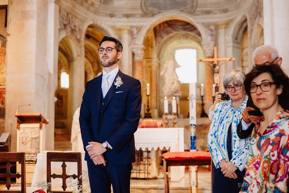 Inside an ornate church with baroque architecture during a wedding ceremony.