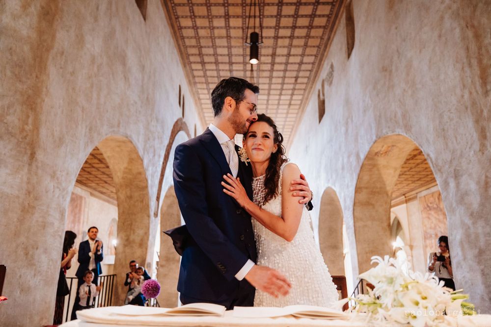 A couple sharing an intimate moment during their wedding ceremony in a historic church.