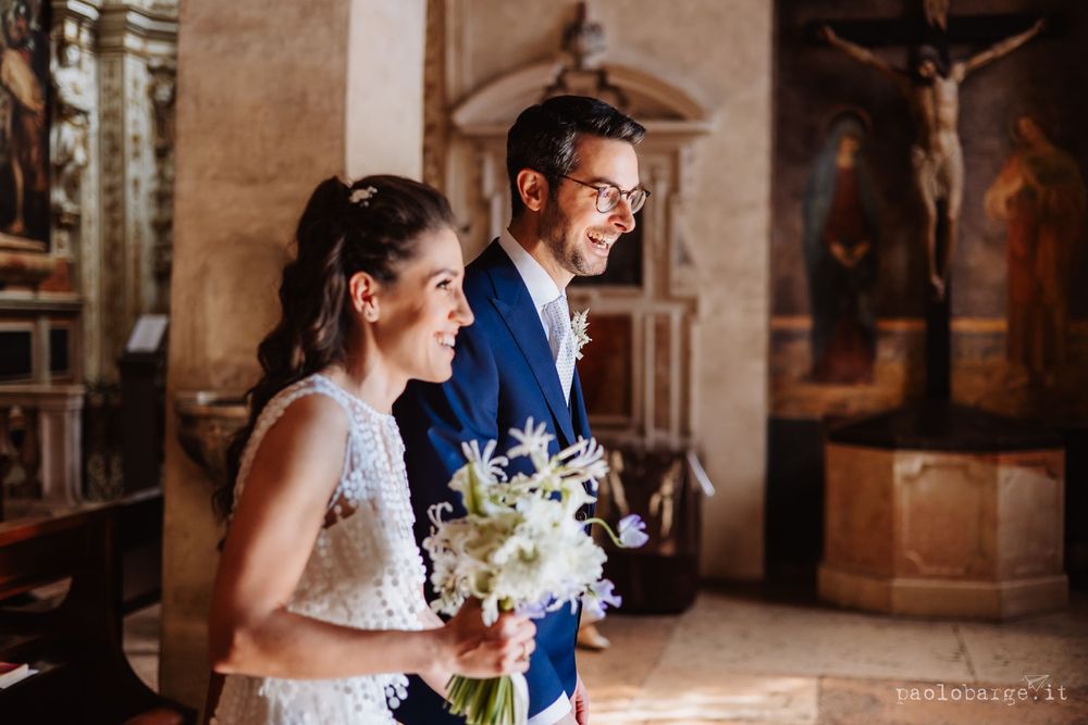 Beautiful wedding ceremony taking place inside a historic church with a traditional crucifix visible in the background.