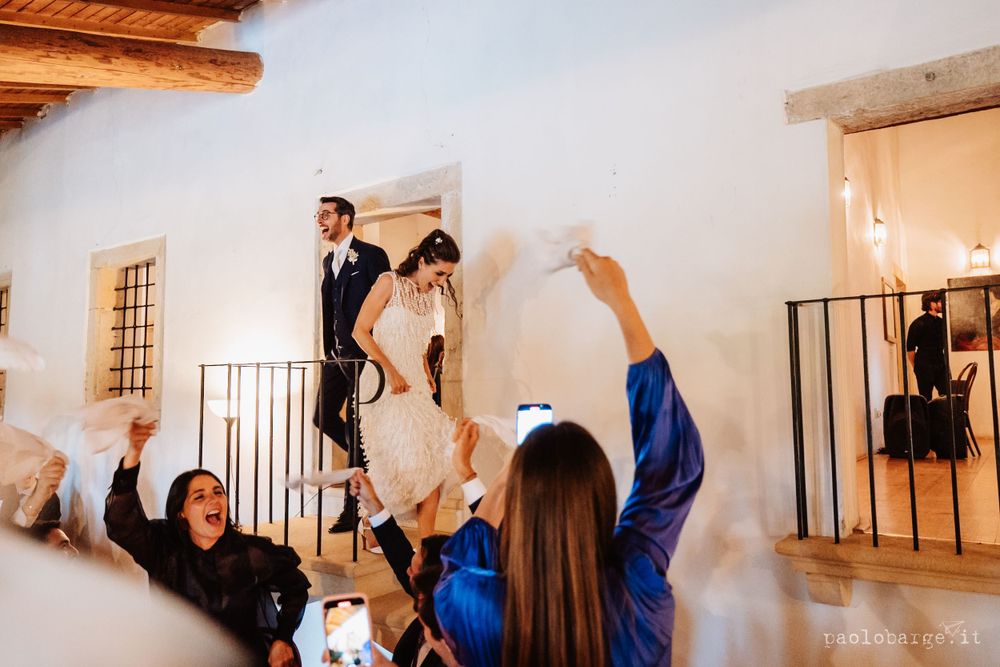 A celebratory moment captured with raised hands and joyful energy in a bright white room.