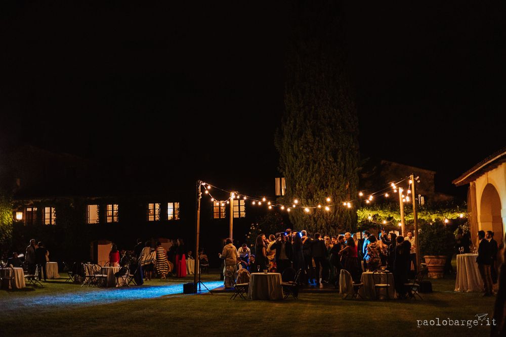 Night reception venue with string lights creating a warm ambiance for gathered guests.
