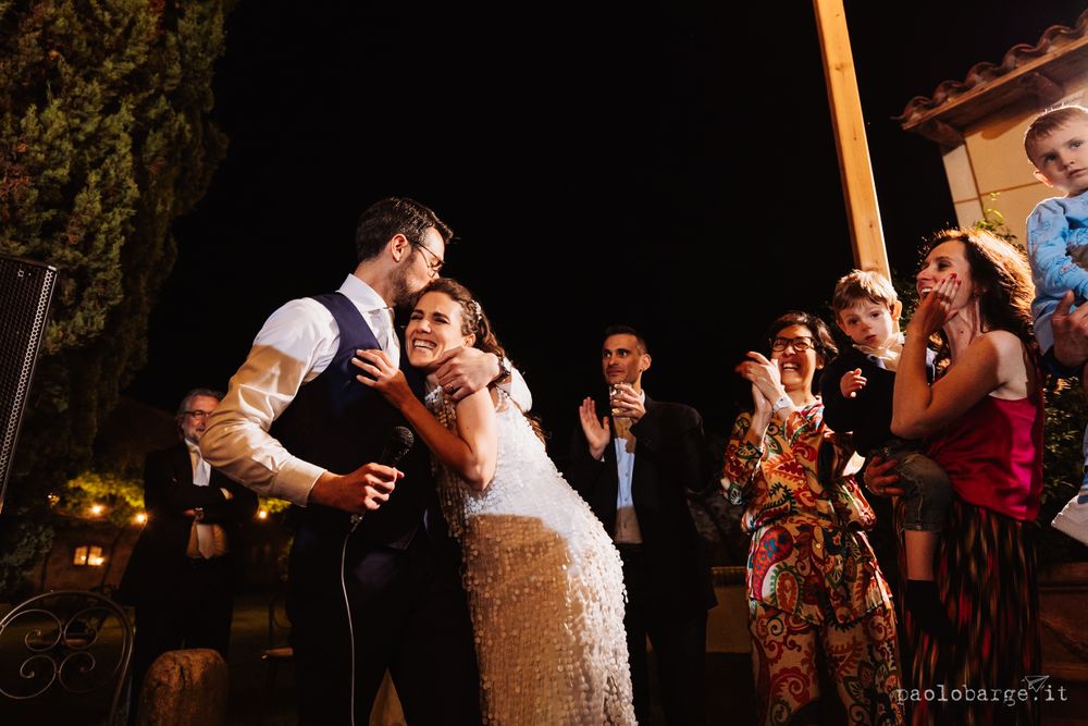Romantic first dance moment under twinkling outdoor lights at night.