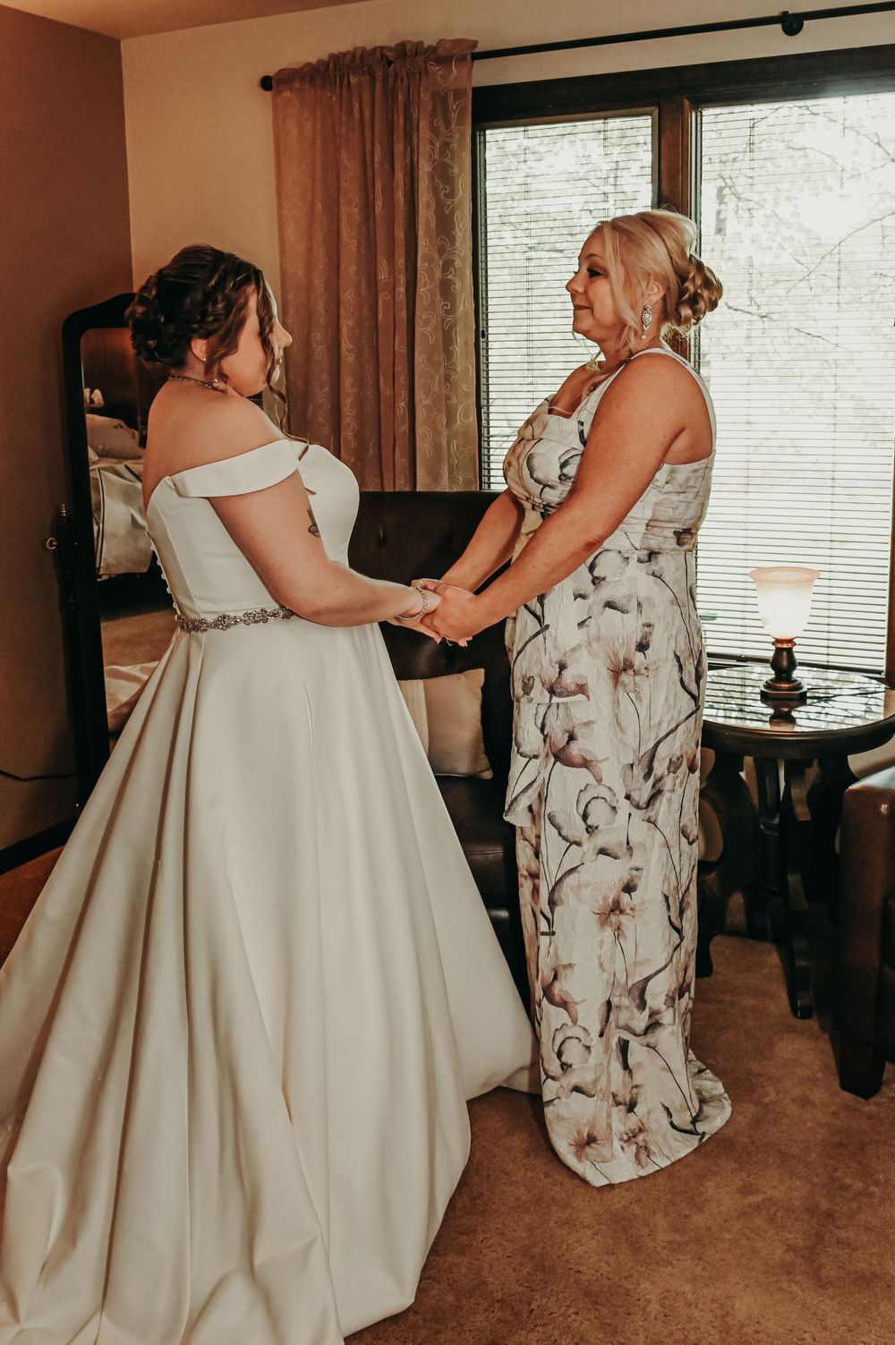 Wedding preparation scene in a room with elegant white dress and floral print attire.