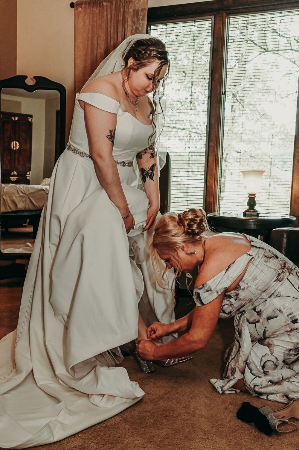 A touching moment between two people in wedding attire as they share an emotional embrace on a carpeted floor.
