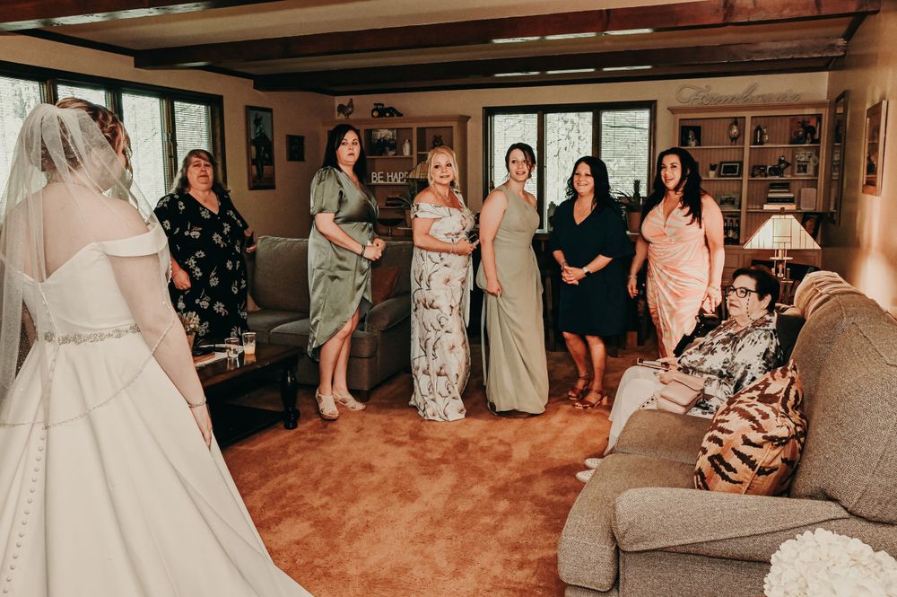 A panoramic view of a wedding ceremony space with guests gathered in a rustic indoor setting.