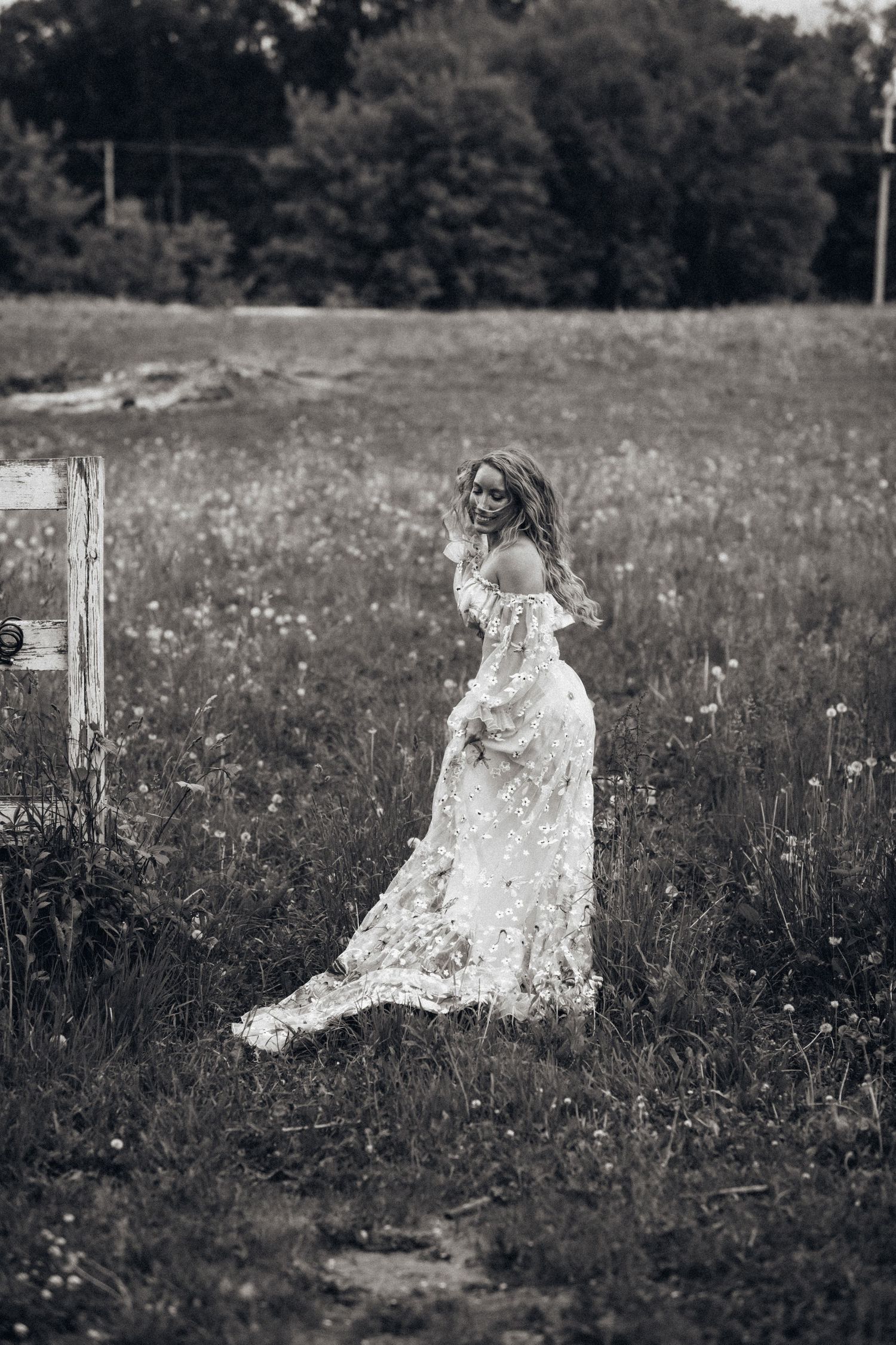 A photographer in a flowing blue dress dances through a sunlit meadow at golden hour.