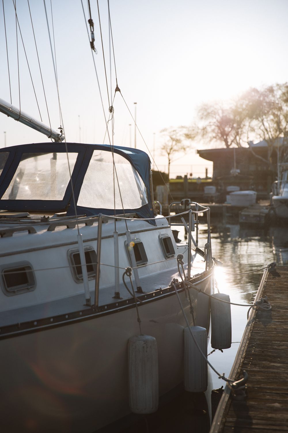 side profile of charter fishing boat docked in marina at sunrise