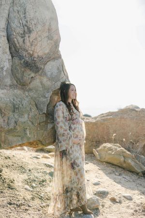 Pregnant mom on rock at the beach. Newborn photography session in Connecticut studio by Ashley Nielsen Studio.