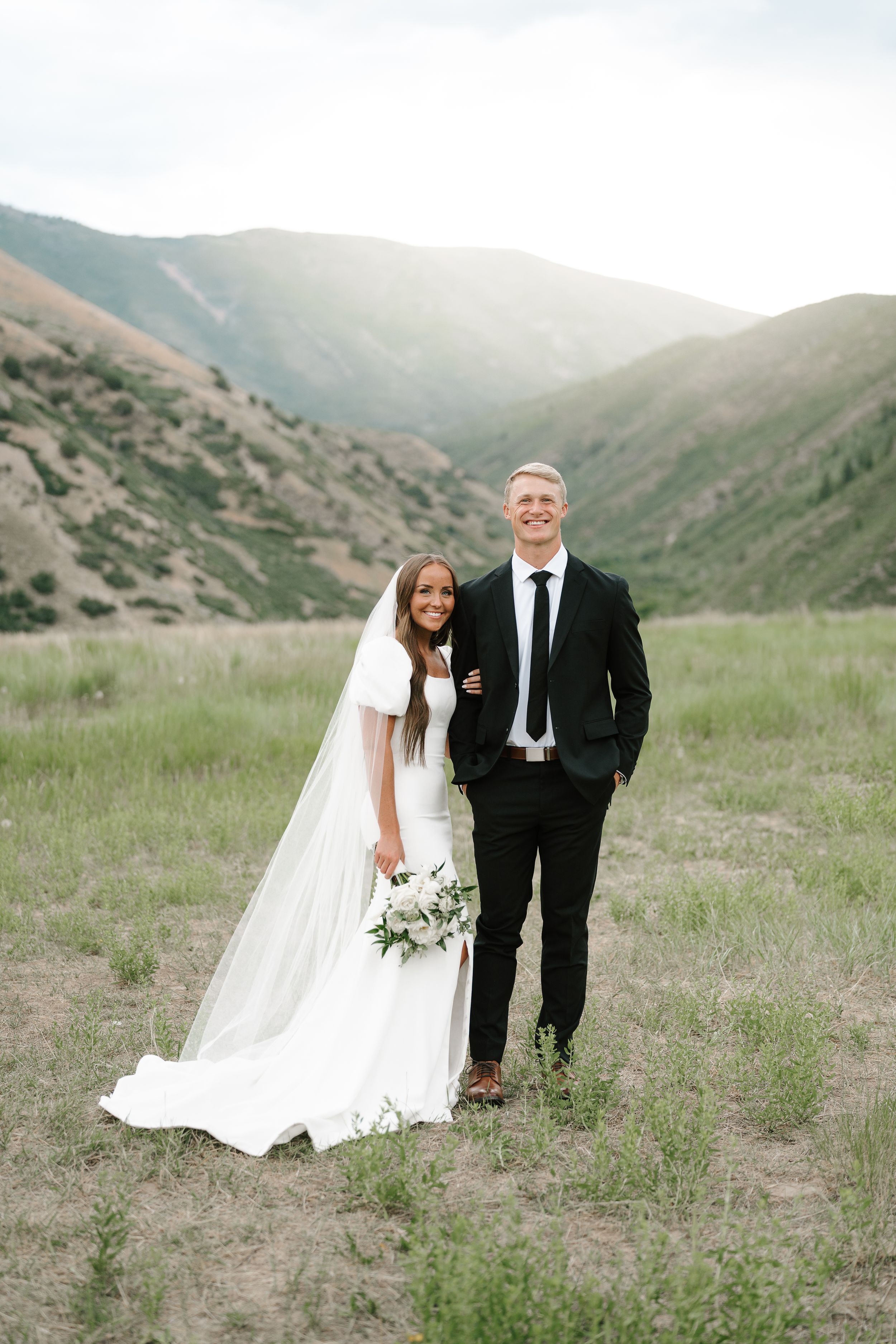 Wedding portrait in mountainous valley with dramatic landscape.