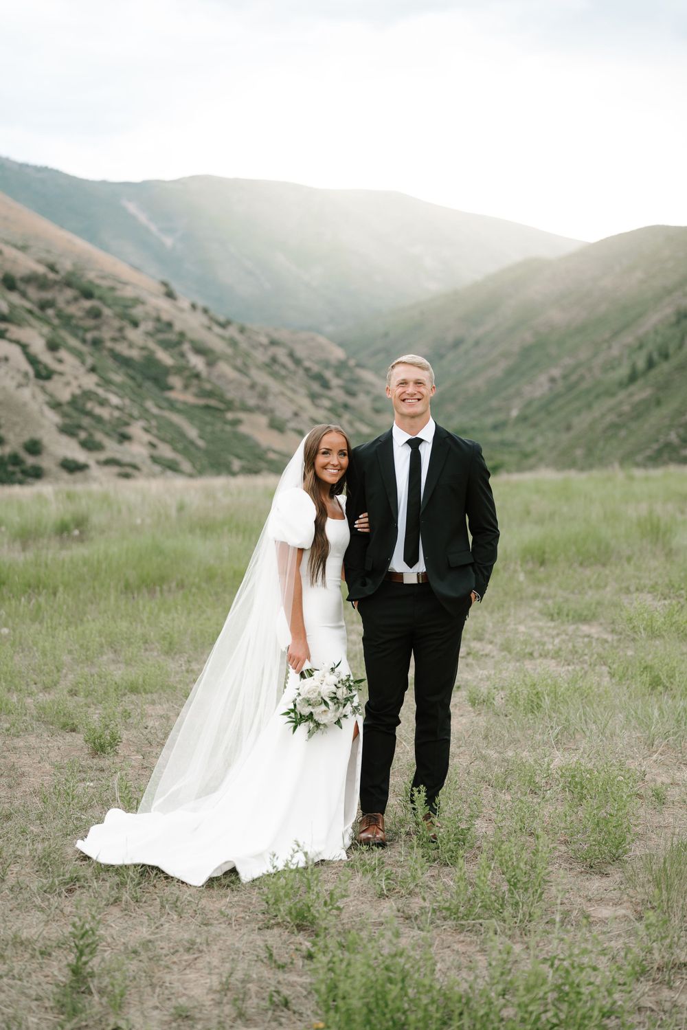 Wedding portrait in mountainous valley with dramatic landscape.