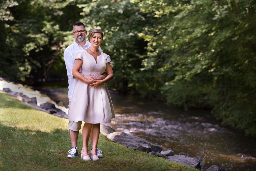 A portrait of a couple posing together by a flowing stream in a peaceful wooded setting.Middletown NJ