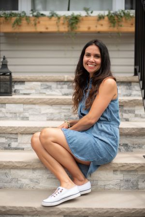 a branding portrait of a woman on concrete steps with greenery and lanterns in middletown NJ