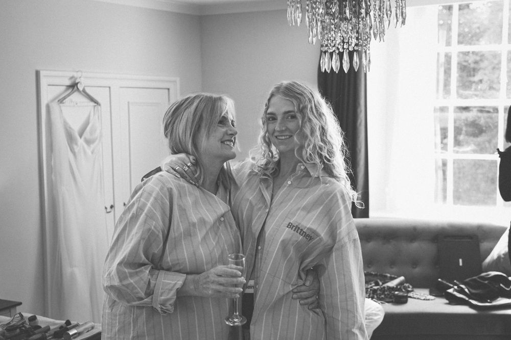 Black and white photo of two people in matching robes sharing a laugh together.