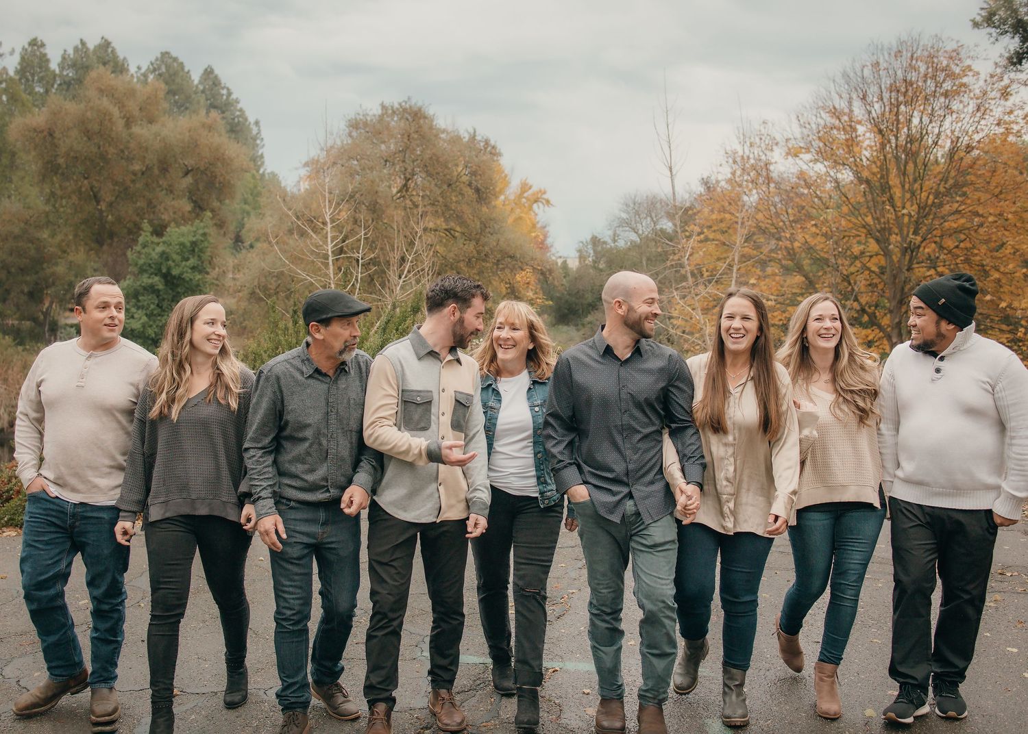 large extended family walks and laughs together in the arboretum in Davis, CA