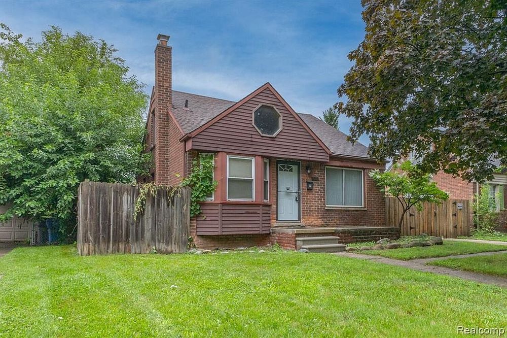 Charming brick bungalow with circular window, chimney, lush green lawn, and mature trees.