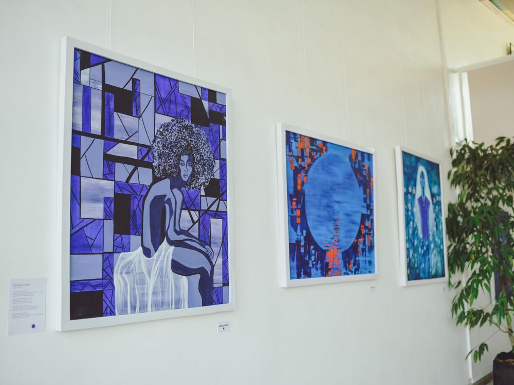 Series of contemporary artwork featuring geometric patterns and blue color schemes hanging on gallery wall.