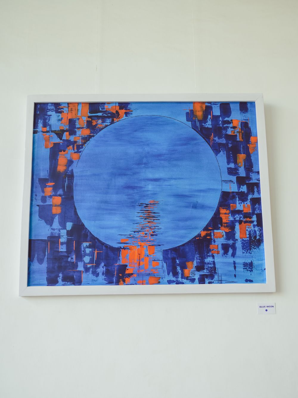 Modern painting with large blue circular element surrounded by geometric orange and blue patterns.