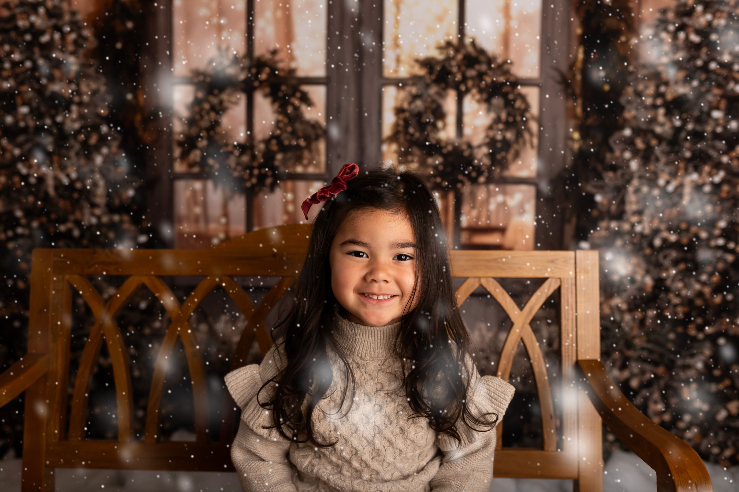 Festive Christmas photo with a cozy sweater against a backdrop of wreaths and twinkling lights.