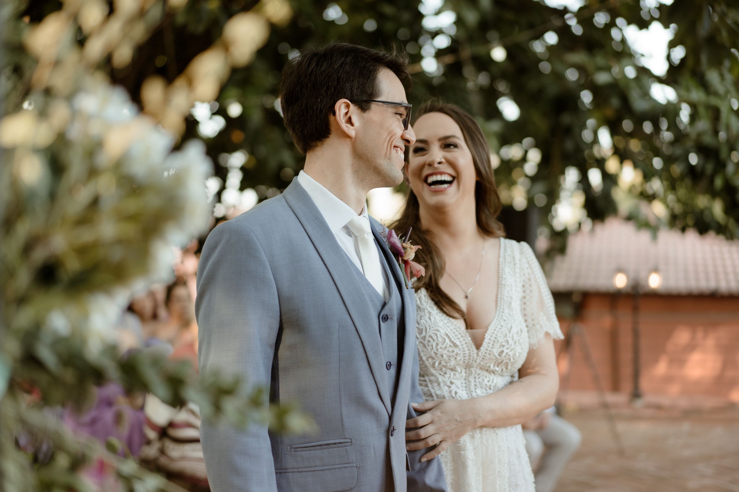 Romantic wedding portrait in natural lighting with elegant gray suit and lace dress.