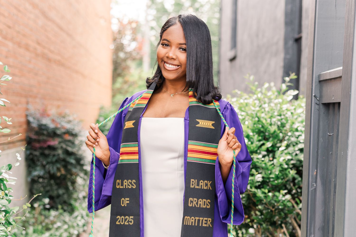 Senior Girl in purple cap and gown with cords.