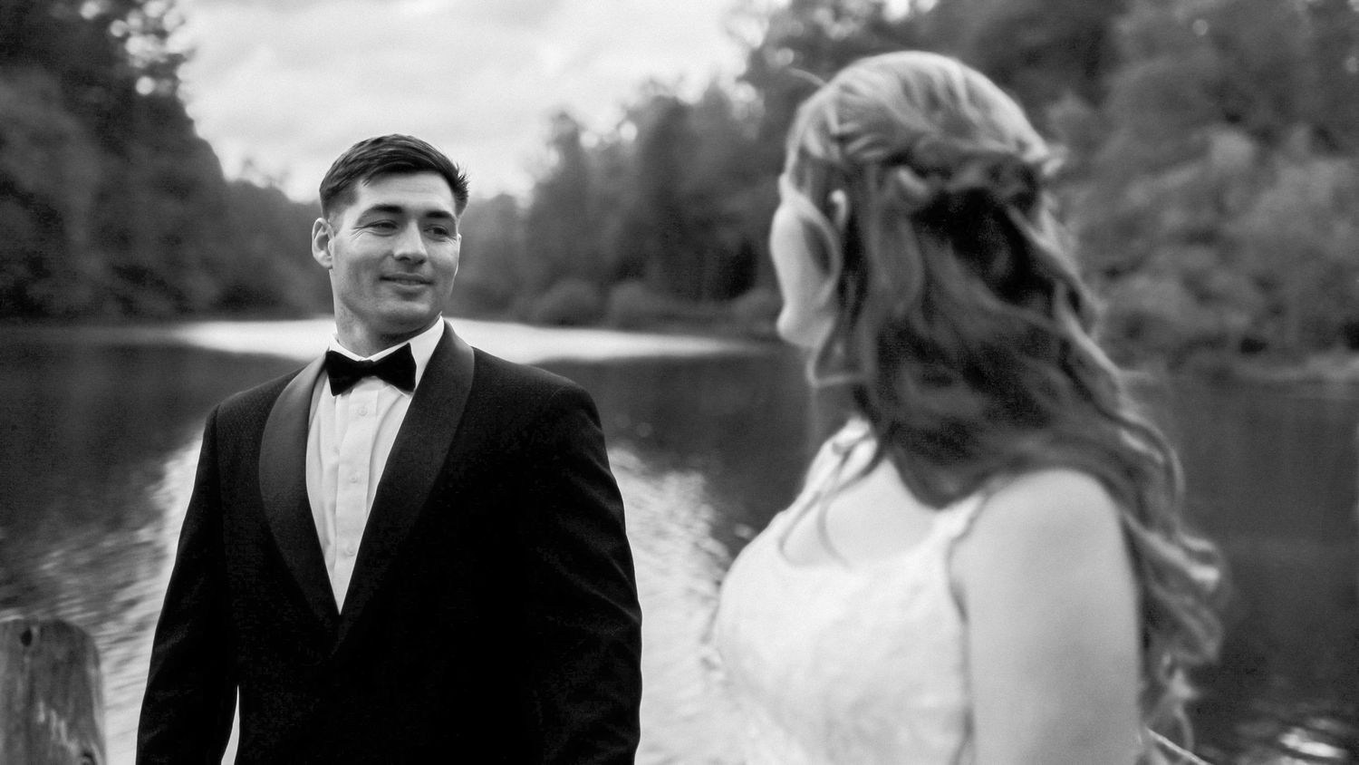 Wedding celebration at golden hour with bride holding bouquet among laughing guests.