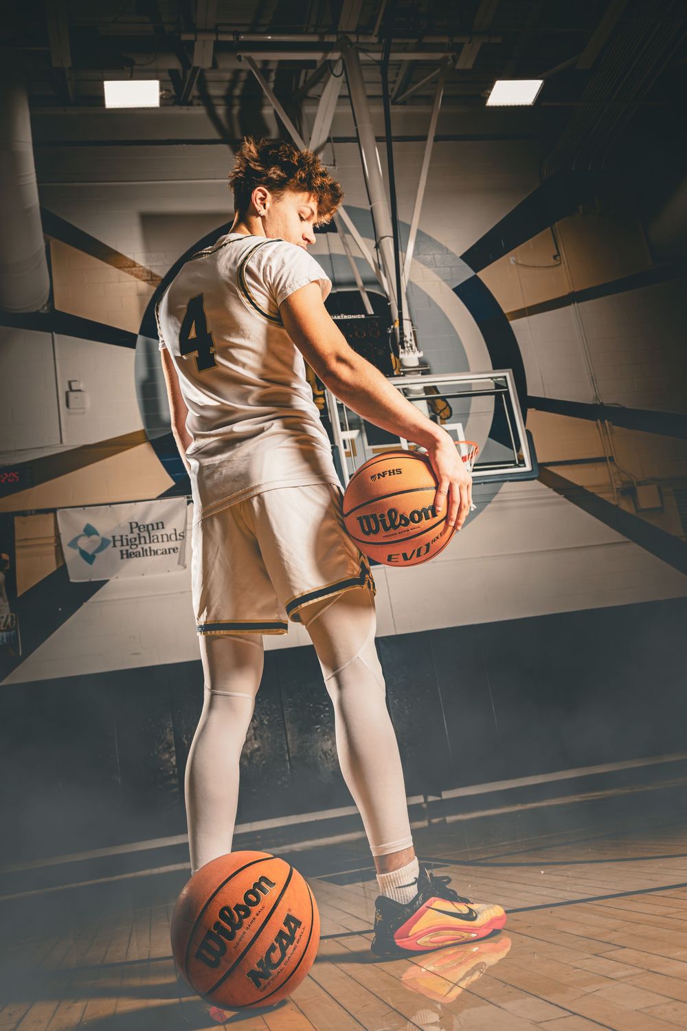 Basketball player practices dribbling skills in a gym with dramatic lighting and multiple action shots shown.