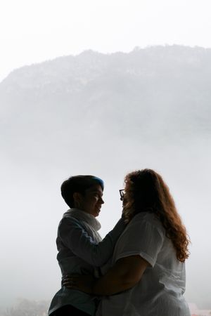 Silhouette d'un couple de femmes en Isère. En arrière-plan, le massif de Chartreuse enveloppé de brouillard.
