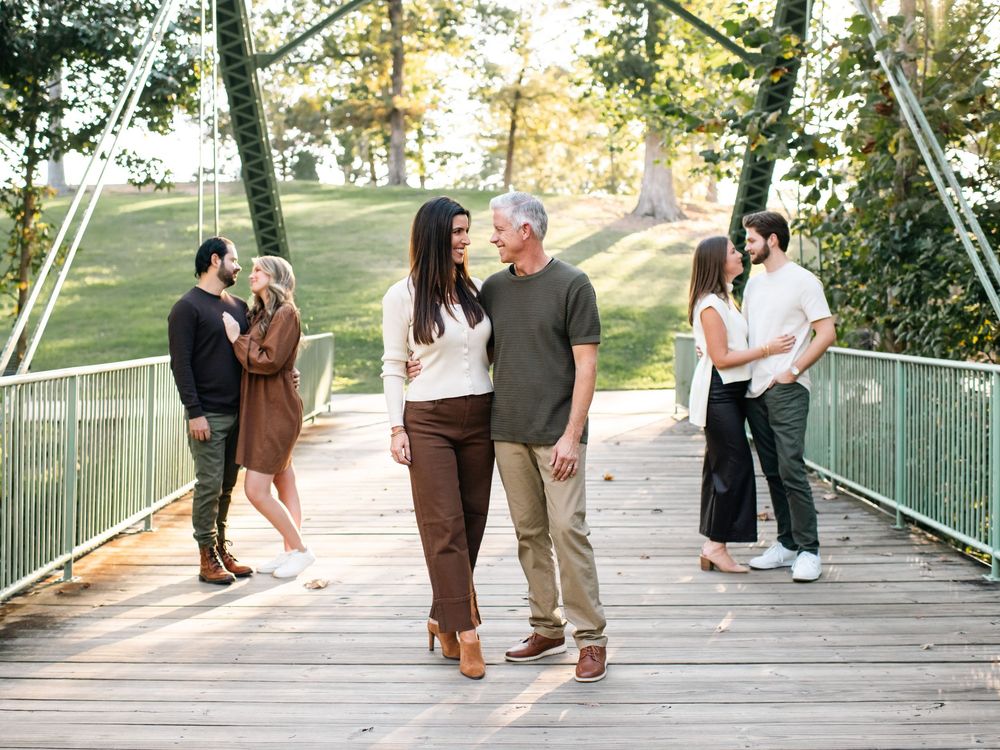 Group walking together on a wooden bridge during sunset photo session.