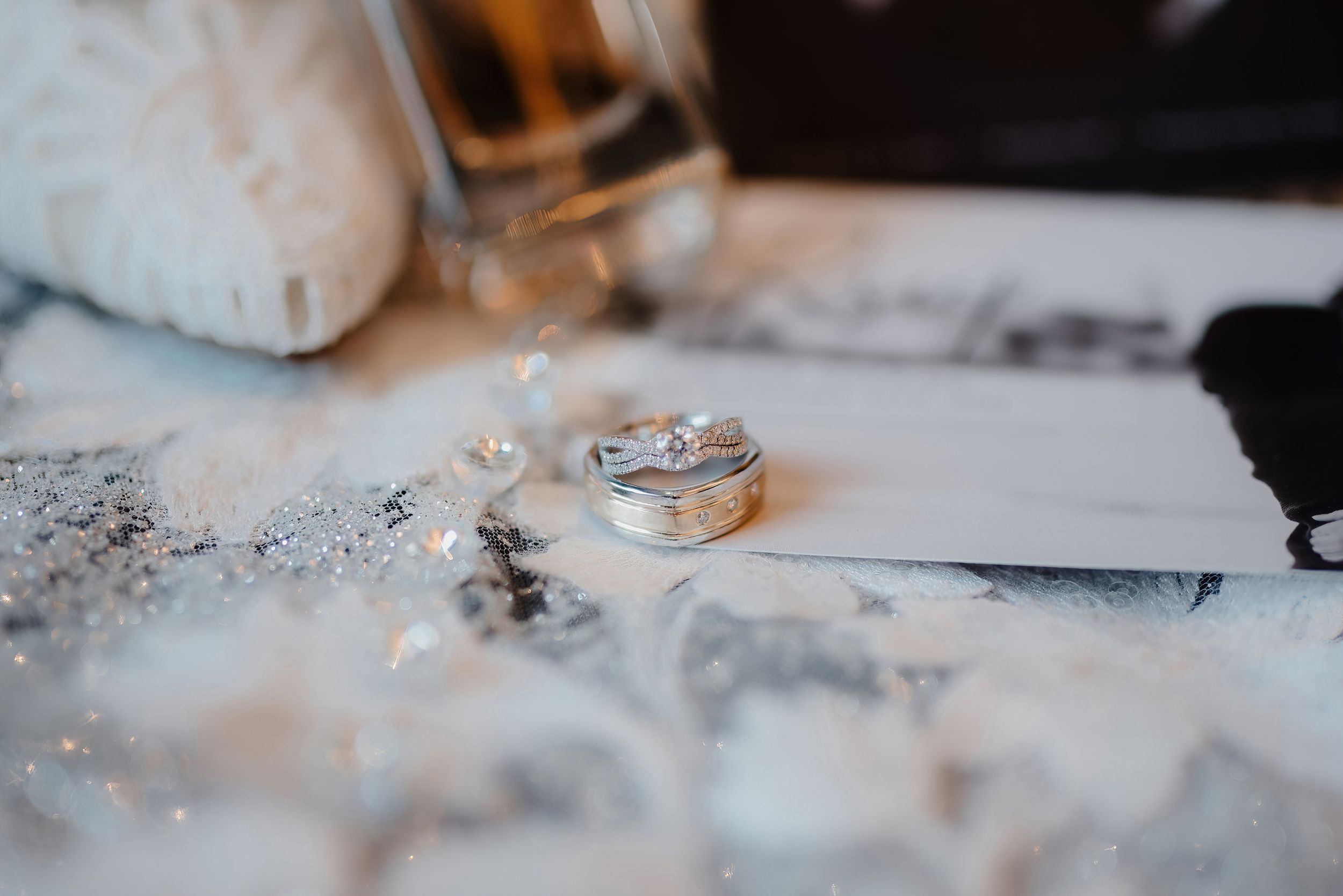 Close-up macro shot of wedding rings on textured white surface with soft focus.