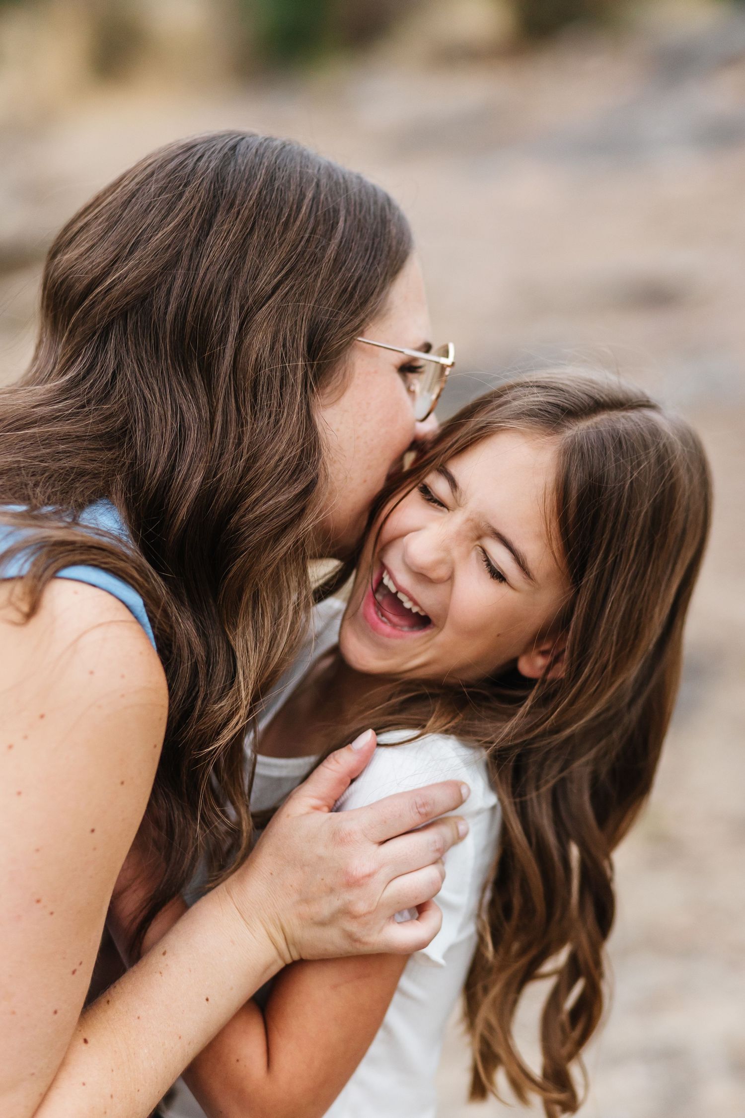 Two people share joyful laughter together in a series of candid outdoor portrait photos.