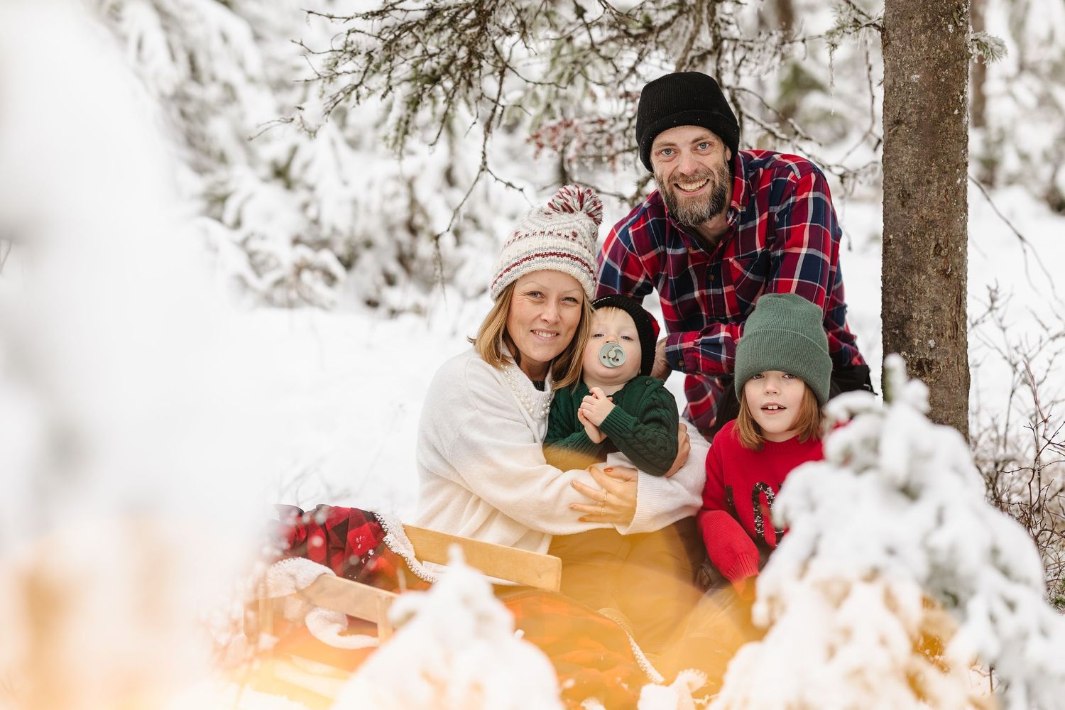 A group of people gather around a cozy campfire in the snow, enjoying winter outdoor activities together.