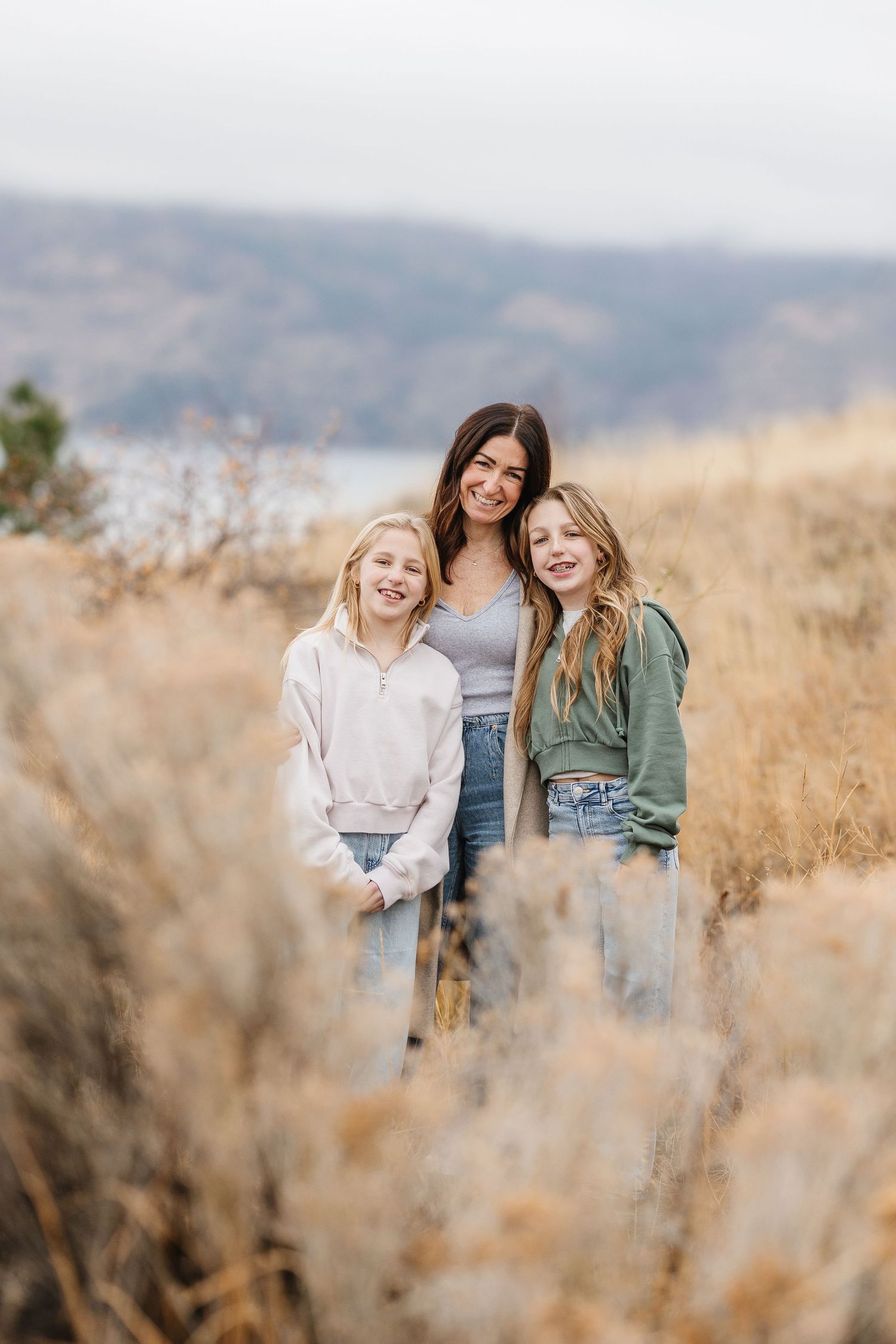 Friends enjoying a sunny autumn day together in a golden field of tall grass and wildflowers.