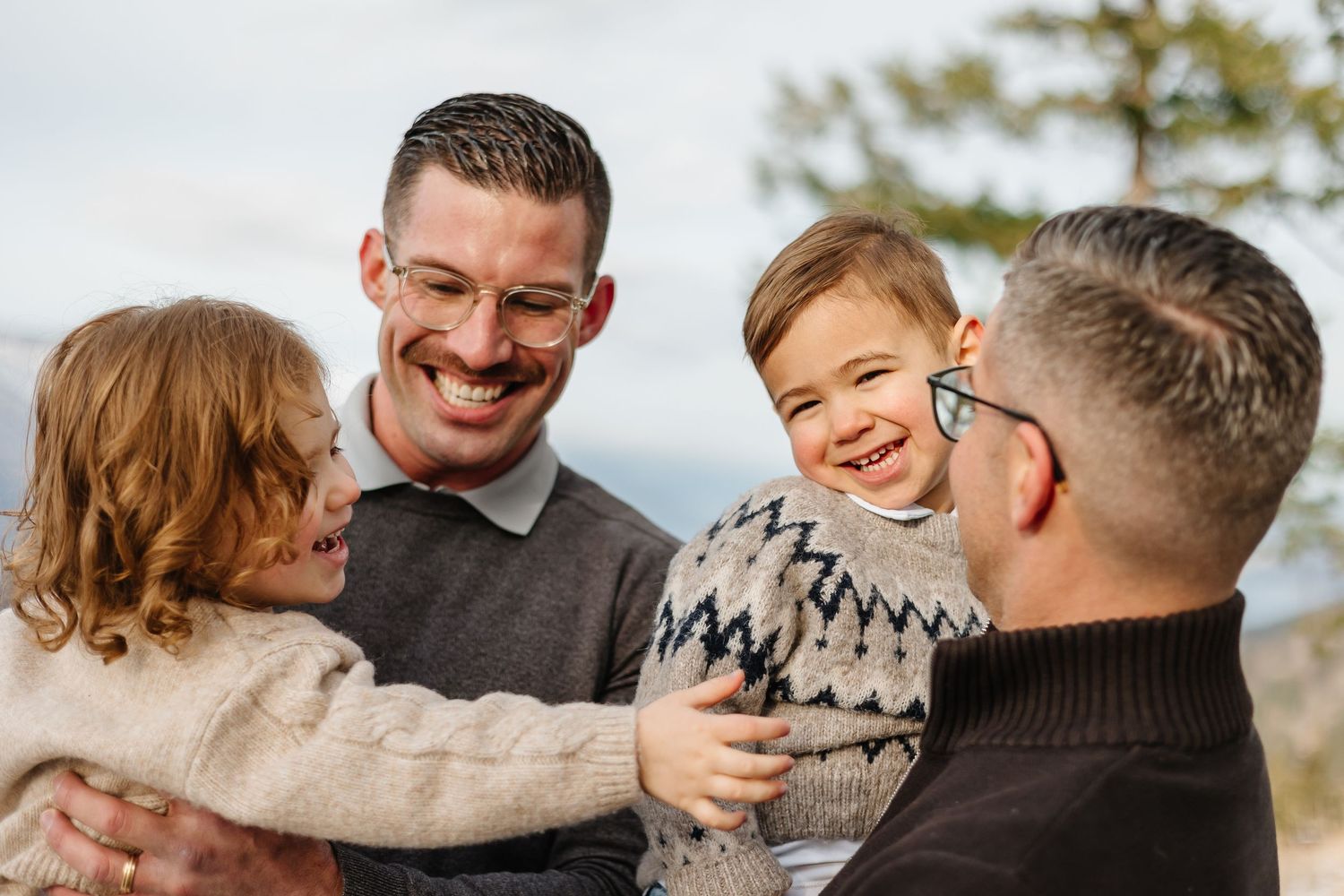 Candid family photos captured during a winter photoshoot with mountain scenery in kelowna