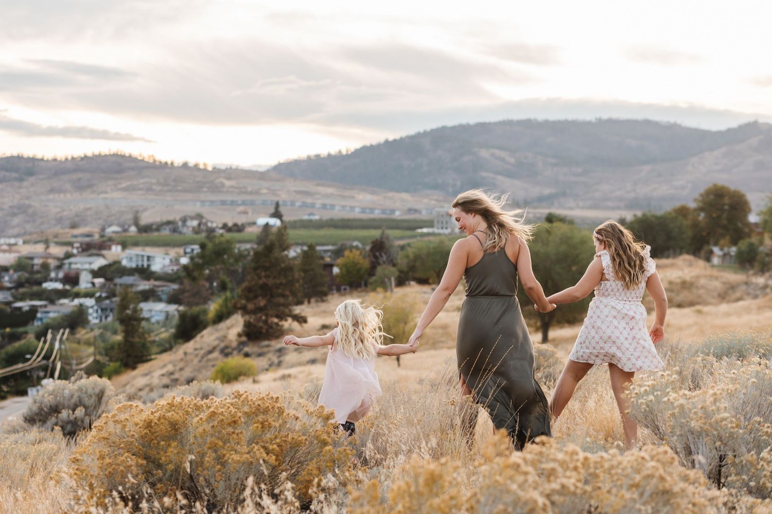 A couple embraces while standing in a scenic mountain landscape during golden hour.
