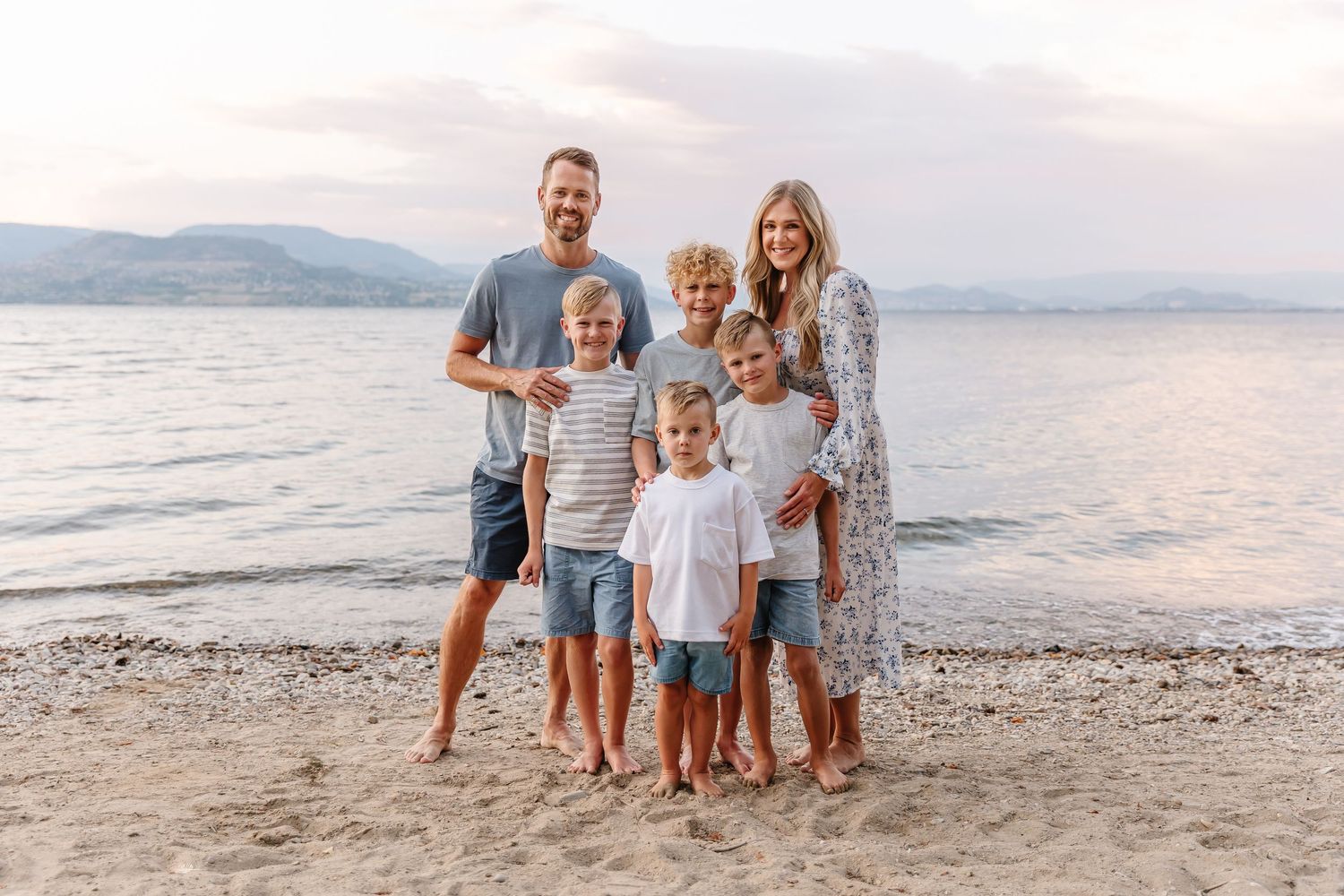 Casual beach photoshoot with mountains and water creating a serene backdrop at dusk in kelowna at Bertram creek park