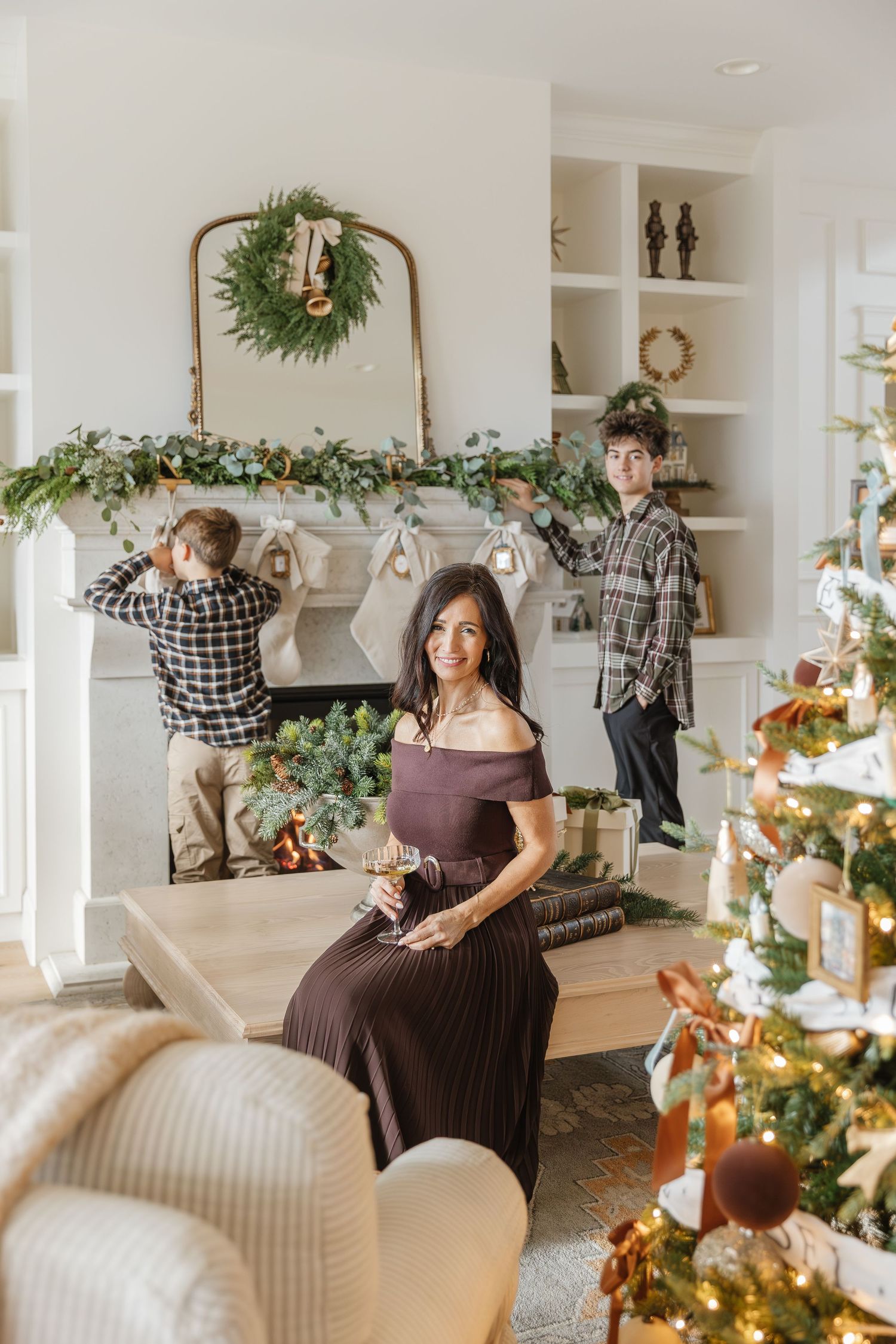 Bright and airy living room decorated for Christmas with garlands, wreaths, and festive holiday decor.
