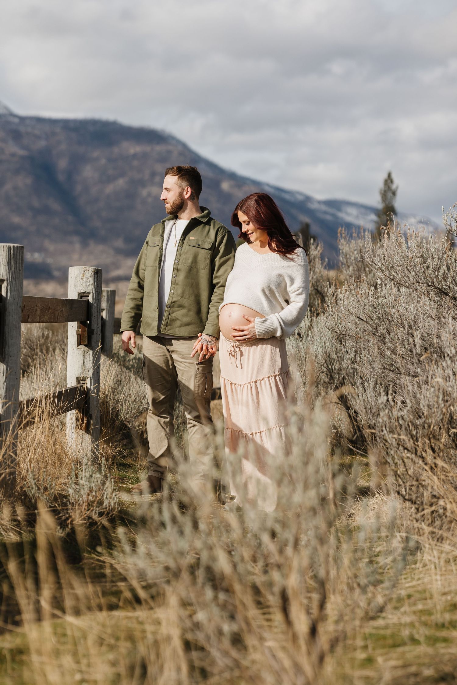 Couples photoshoot in outdoor setting with mountains and sagebrush  sharing romantic moments in soft natural lighting at Knox Mountain