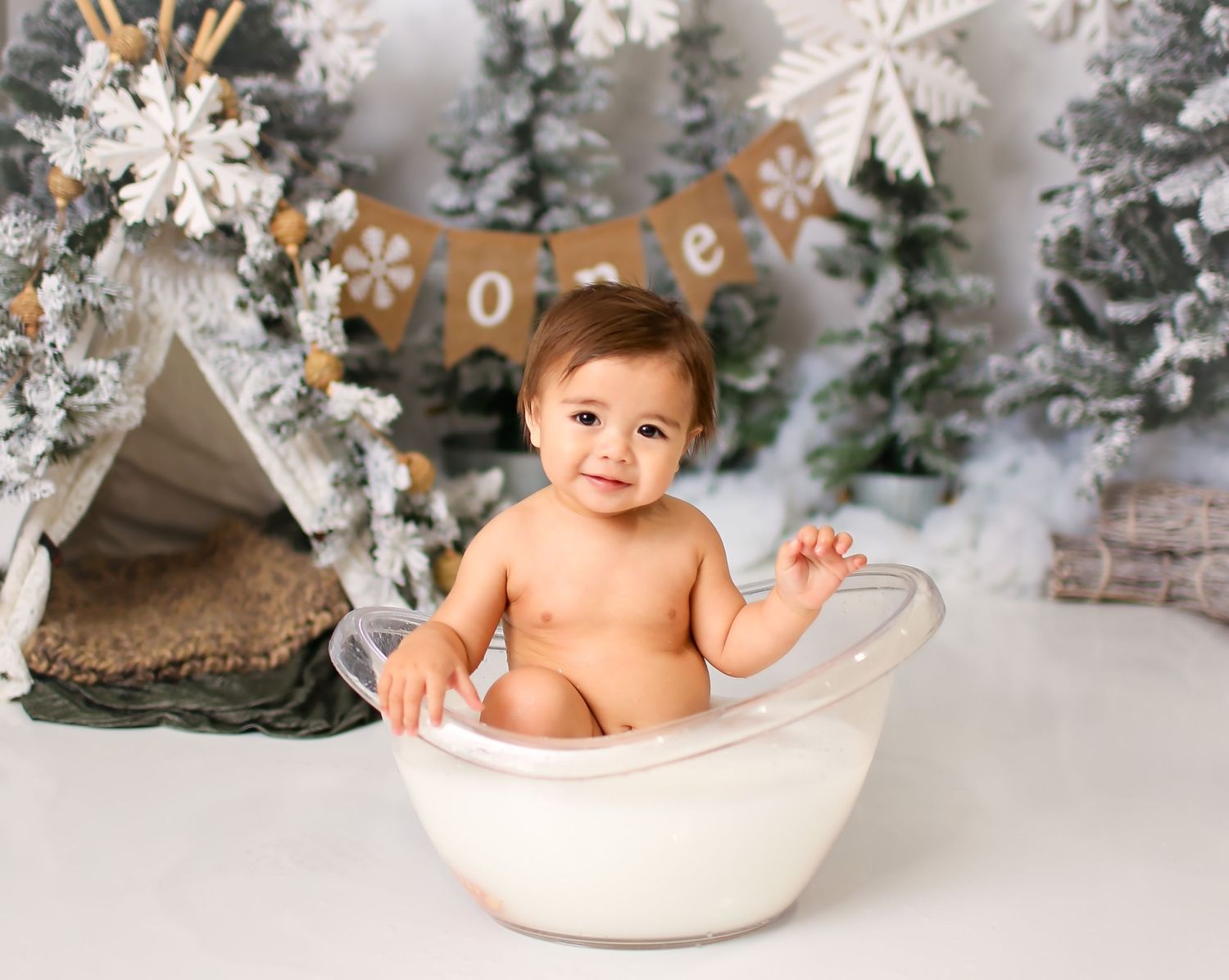 Baby boy  in studio for first birthday session while having a milk bath Winter theme