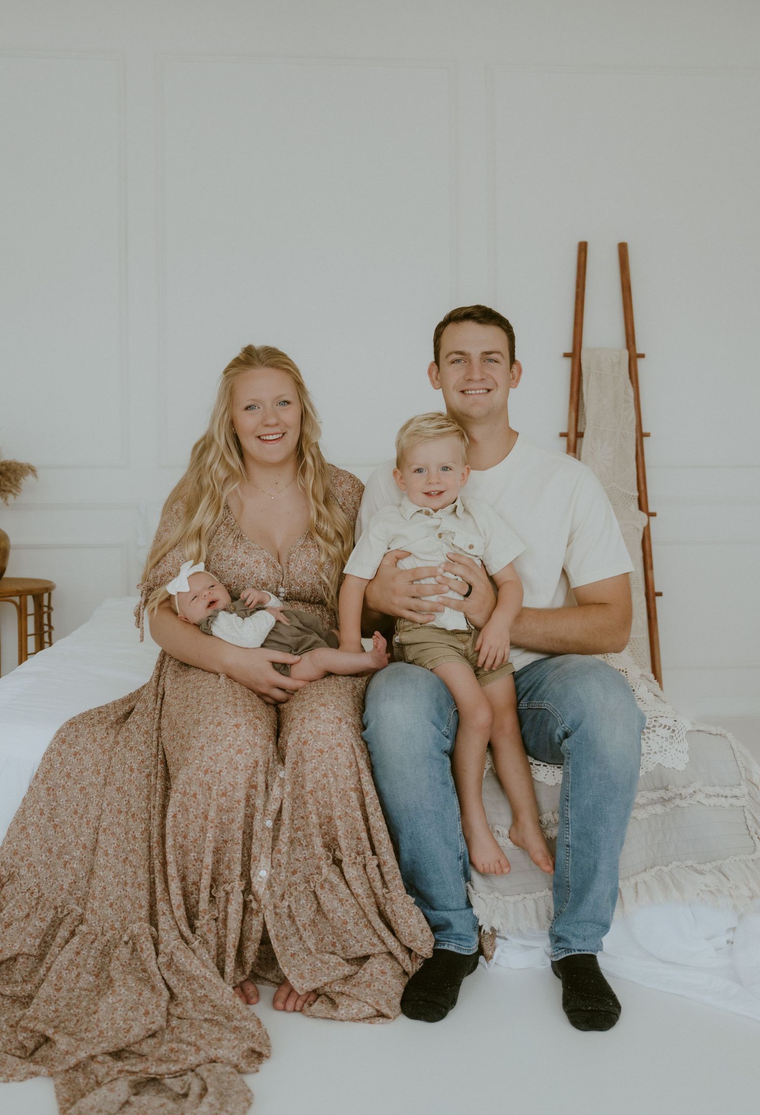 A family portrait in a bright white room with casual attire.
