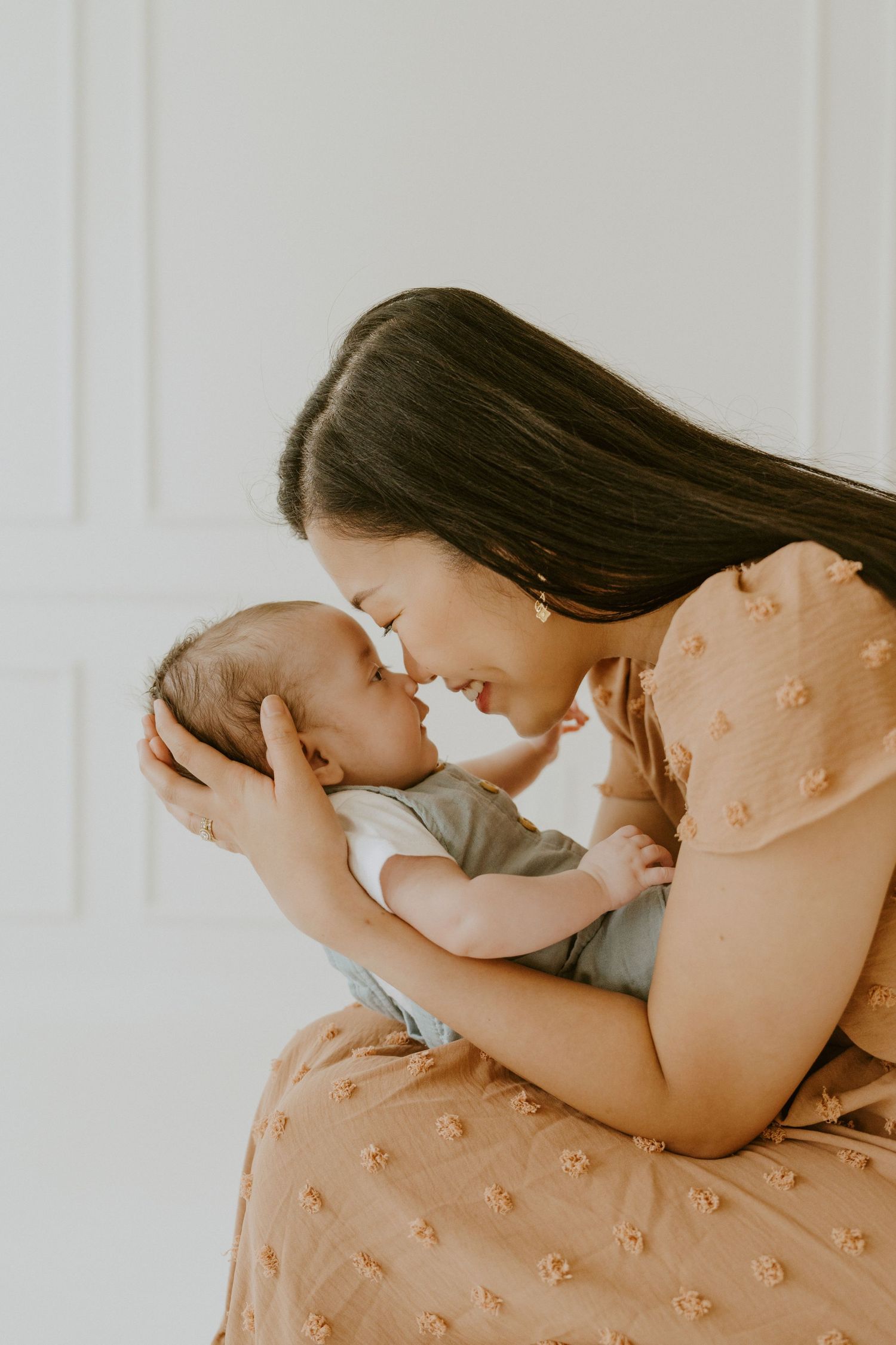 A tender moment between parent and newborn baby in a warm, intimate setting.